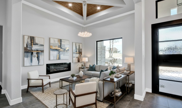 Modern living room with gray sofa, abstract art, and natural lighting.