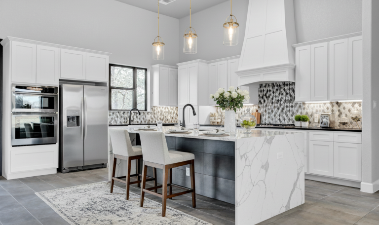 Contemporary kitchen with marble island, pendant lights, and stainless steel appliances.