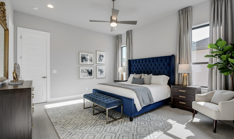 Spacious bedroom with blue upholstered bed and neutral tones.